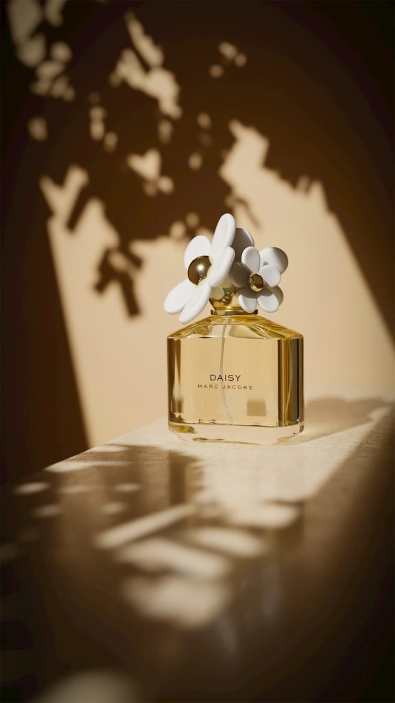 a-bottle-of-daisy-perfume-with-floral-accents-syb0kqmt2ay