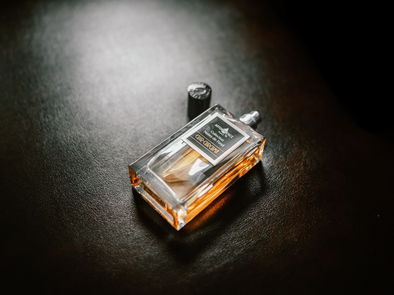 Luxurious perfume bottle with copy space on a textured dark background.