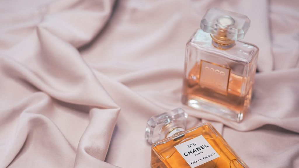 Luxurious perfume bottles displayed on soft pink silk exuding elegance.
