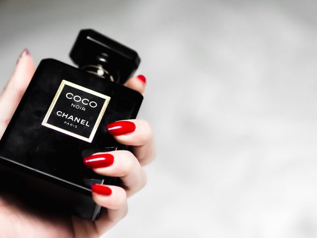 person-holding-black-and-gold-perfume-bottle-8wlm9twbnja